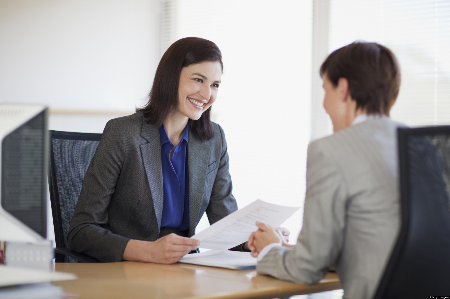 Businesswomen with paperwork talking face to face